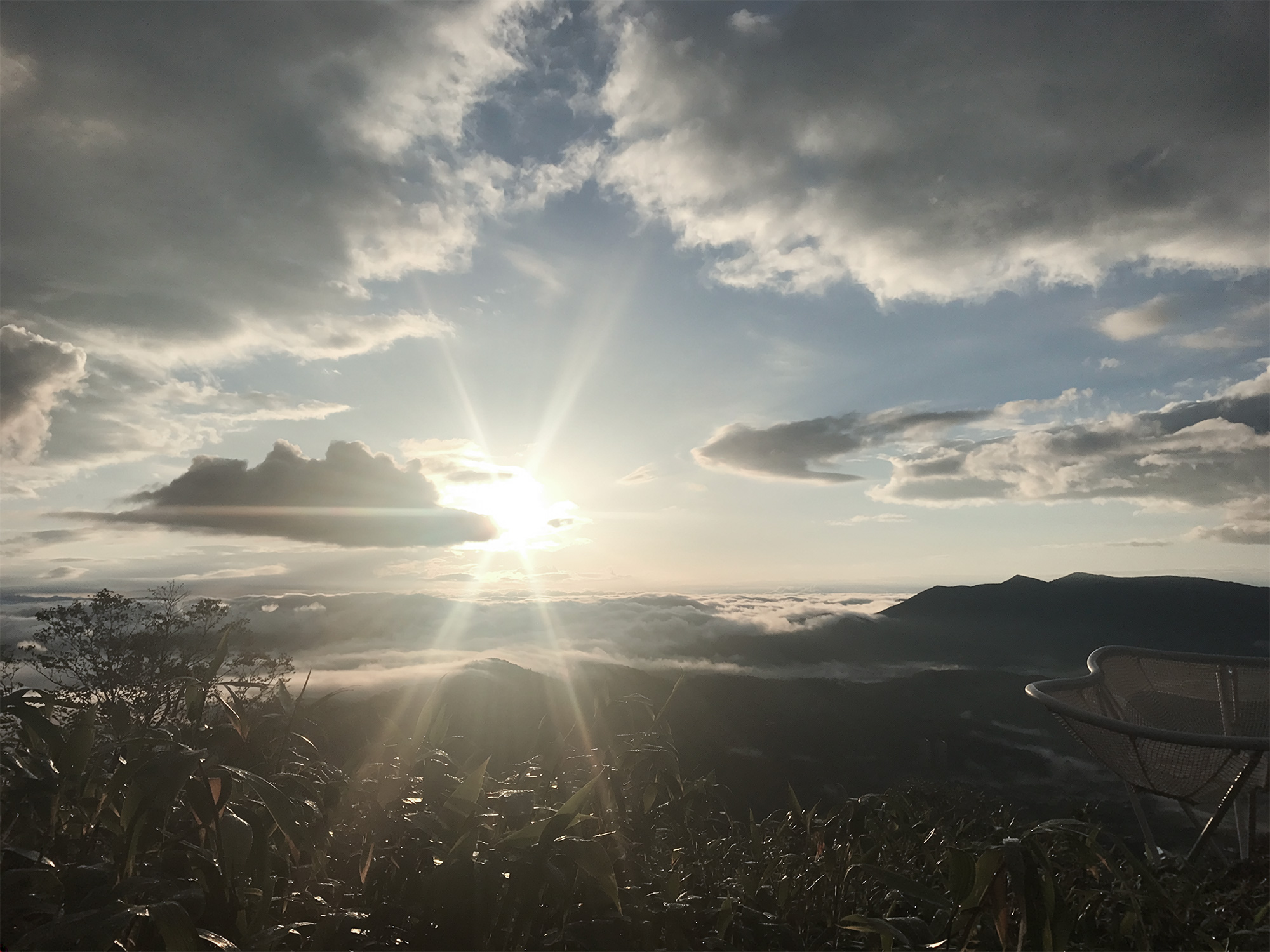 雲海と光芒が広がる夜明けの山の風景